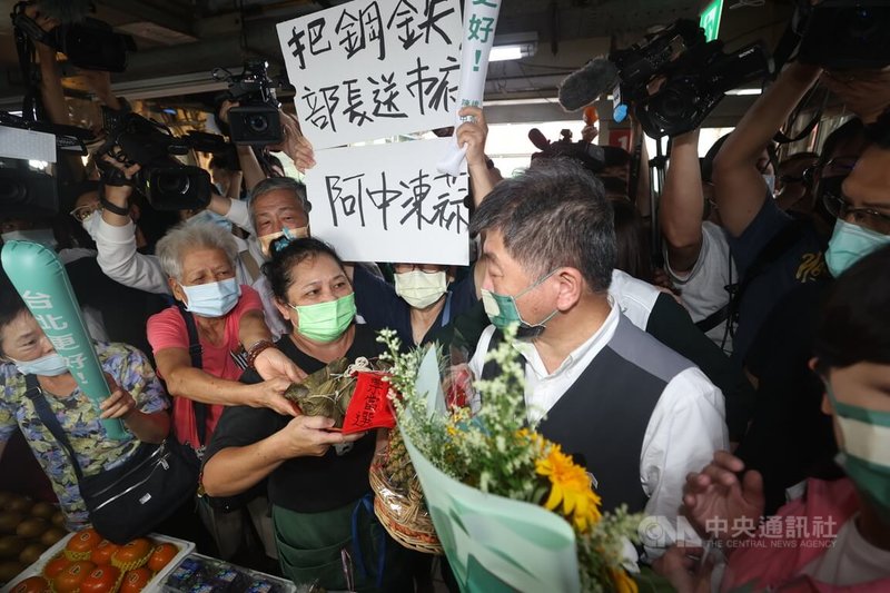 民進黨台北市長參選人陳時中（前右）5日上午在北投市場掃街拜票，民眾送上粽子，祝福高票當選。中央社記者吳家昇攝  111年10月5日