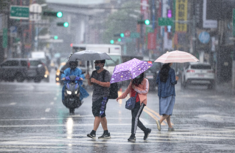 圖為9月台北市中正區下起大雨，民眾快步過馬路。（中央社檔案照片）