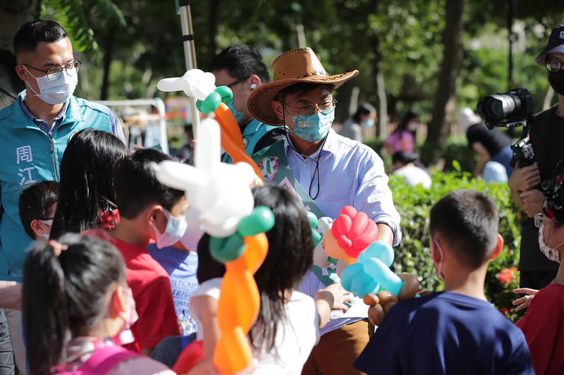 民進黨新竹縣長參選人周江杰（後中）8日在竹北市水圳公園舉辦「幸福江江好–親子公益活動」，以園遊會形式結合在地藝術家作品義賣、二手跳蚤市場等方式與大小朋友們同樂。（周江杰競選辦公室提供）中央社記者魯鋼駿傳真  111年10月8日