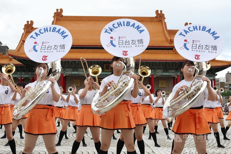 將於國慶典禮上演出的日本京都橘高校吹奏部學生，9日下午在兩廳院戶外廣場與北一女中樂儀旗隊、曉明女中管樂團交流演出，樂器上掛著牌子寫有「台日友情」字樣。中央社記者趙世勳攝 111年10月9日