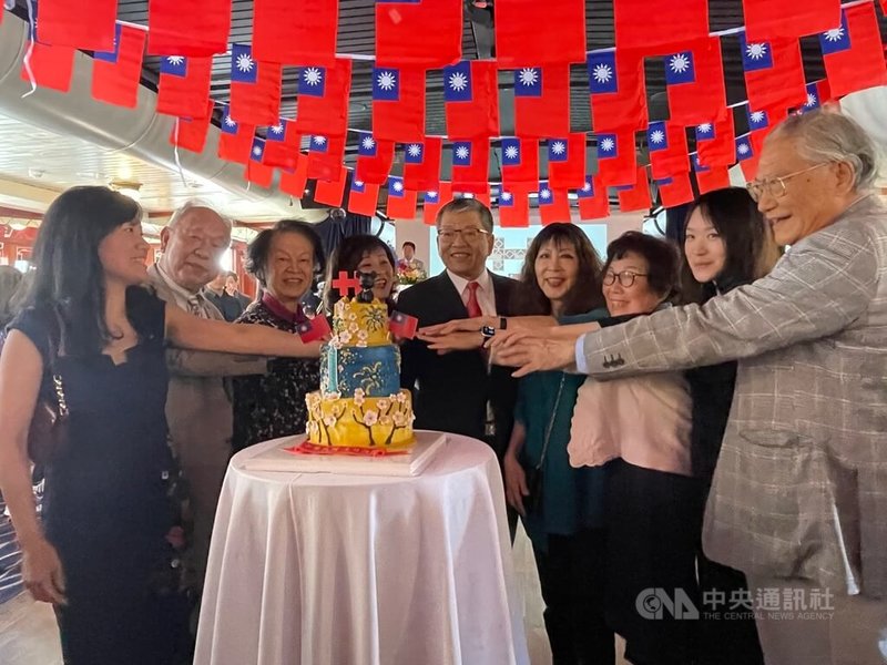 英國僑界8日舉行國慶，跨世代僑民共享特別製作的國慶主題蛋糕。駐英國代表謝武樵（右5）期勉眾人時刻不忘台灣，主辦活動的輔仁大學英國校友會會長黃瑋苑（左1）稱任何新故鄉都比不上台灣。中央社記者陳韻聿倫敦攝 111年10月10日
