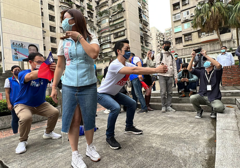 國民黨台北市長參選人蔣萬安（中）10日上午出席興安華城社區慶祝國慶升旗典禮，會後在社區中庭示範「深蹲」。中央社記者鄭傑文攝  111年10月10日