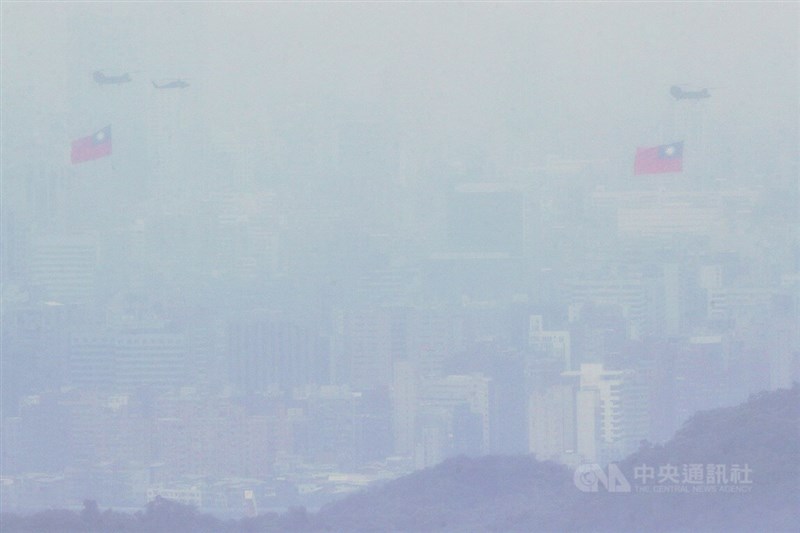 中華民國中樞暨各界慶祝111年國慶大會10日登場，國軍CH-47SD契努克運輸直升機吊掛巨幅國旗，與UH-60M黑鷹直升機在雲霧中飛行。中央社記者裴禛攝 111年10月10日