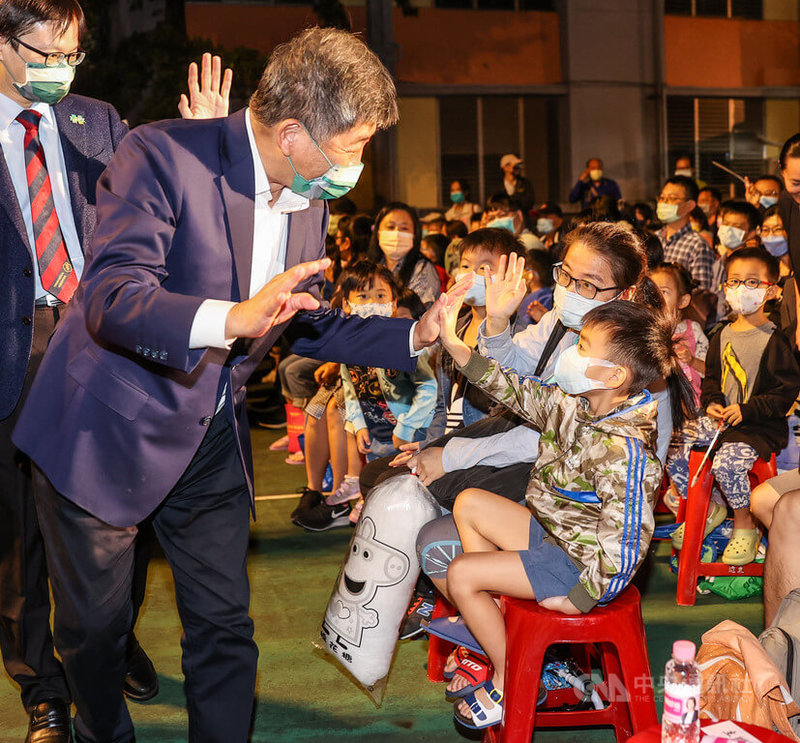 紙風車劇團「巫頂環遊世界」文山首演場10日晚間在木柵國中登場,民進黨台北市長參選人陳時中(前左)出席與會,入場時和現場小朋友擊掌致意。中央社記者鄭清元攝 111年10月10日