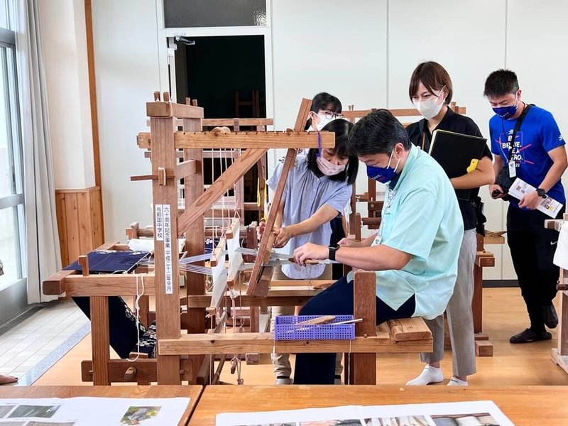 花蓮市長魏嘉賢率團訪日，前往與那國町進行4天參訪活動，圖為魏嘉賢（前右）至與那國中學，體驗編織技藝。（花蓮市公所提供）中央社記者張祈傳真  111年10月11日