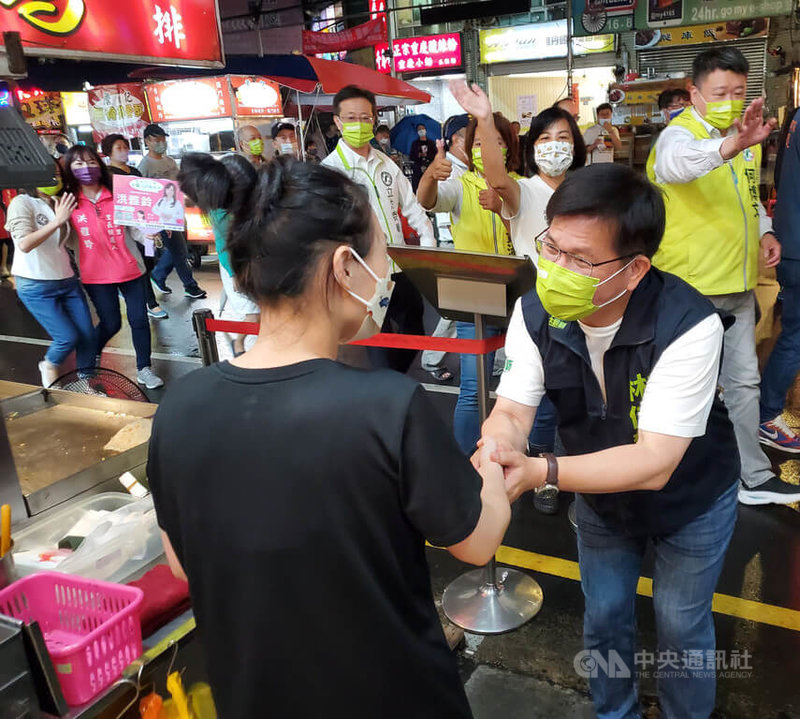 民進黨新北市長參選人林佳龍（前右）12日晚間帶隊前往板橋區湳雅夜市掃街拜票，向店家攤商握手致意，尋求支持。中央社記者王鴻國攝  111年10月12日