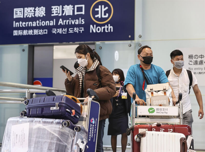圖為日本關西機場12日入境旅客。（共同社）