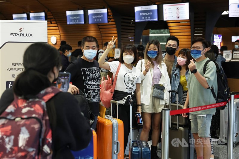 台灣邊境13日鬆綁，入境改為「0+7」，日、韓、泰也大幅解封；上午桃園機場第一航廈報到櫃檯處，民眾開心合影，慶祝久違的出國旅遊。中央社記者趙世勳攝 111年10月13日