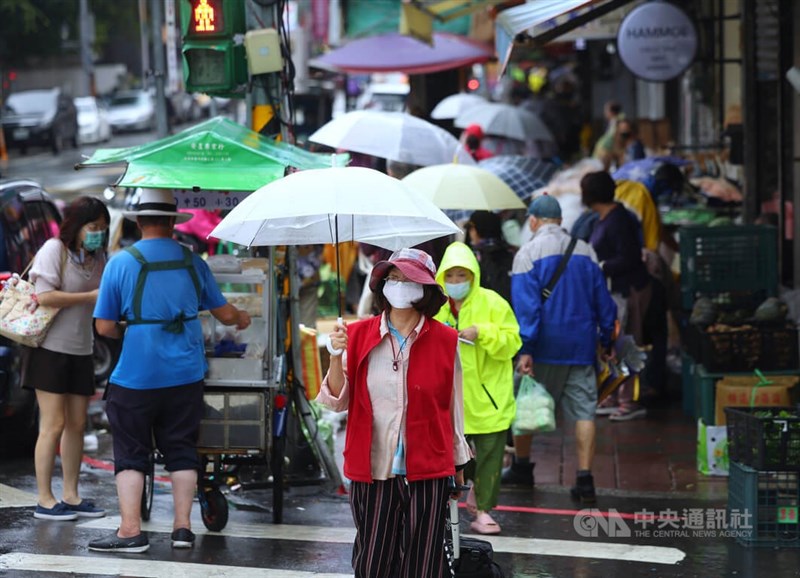 中央氣象局16日表示，受到颱風尼莎外圍環流影響，易有短延時強降雨，台北、宜蘭防超大豪雨。圖為台北民眾16日上午撐傘、穿雨衣到雙連市場採買。中央社記者趙世勳攝　111年10月16日