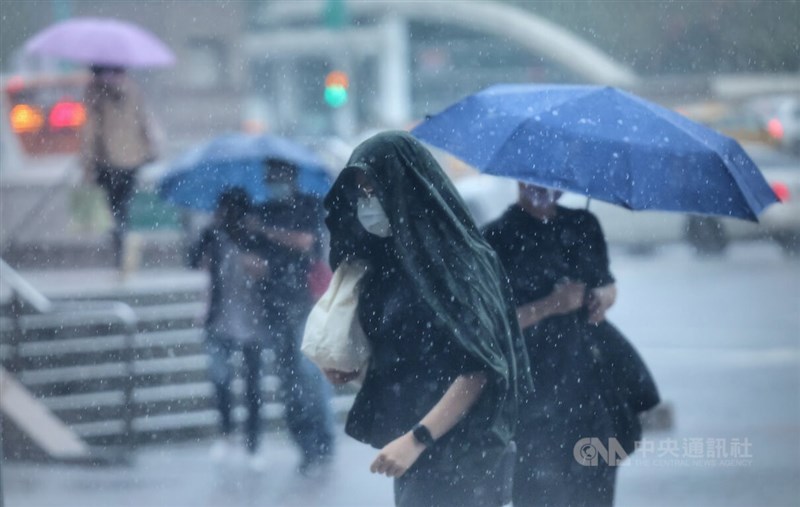 颱風尼莎外圍環流及東北季風影響，16日白天全台各地有雨，北北基桃、宜花等地區較顯著，預估16日晚間至17日北北基桃雨勢還是會持續。台北市中正區有民眾利用衣服擋雨。中央社記者王飛華攝 111年10月16日