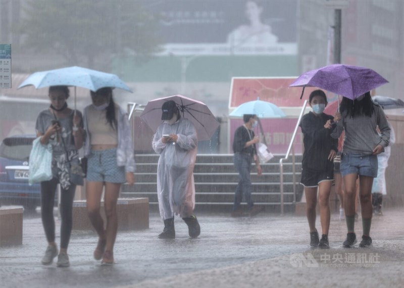 氣象局17日發布豪雨特報，台北市山區防局部豪雨或大豪雨，基隆市、新北市、宜蘭縣防豪雨。圖為民眾在台北中正區街頭撐傘遮擋雨勢。（中央社檔案照片）