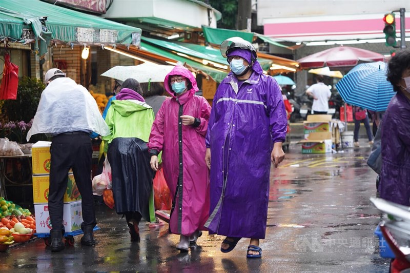 氣象局17日更新豪雨特報，台北市山區防超大豪雨。圖為民眾穿著雨衣在北投市場採買。（中央社檔案照片）