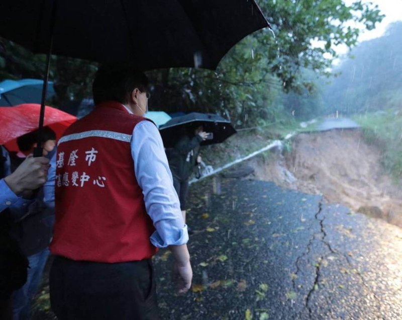 基隆市七堵區華新一路道路17日發生坍塌，市長林右昌（右）下午前往勘災，預計18日雨勢稍歇後，先以鋼板樁穩定邊坡，再從旁開闢便道搶通，滿足民眾緊急通行需求。（基隆市政府提供）中央社記者王朝鈺傳真  111年10月17日