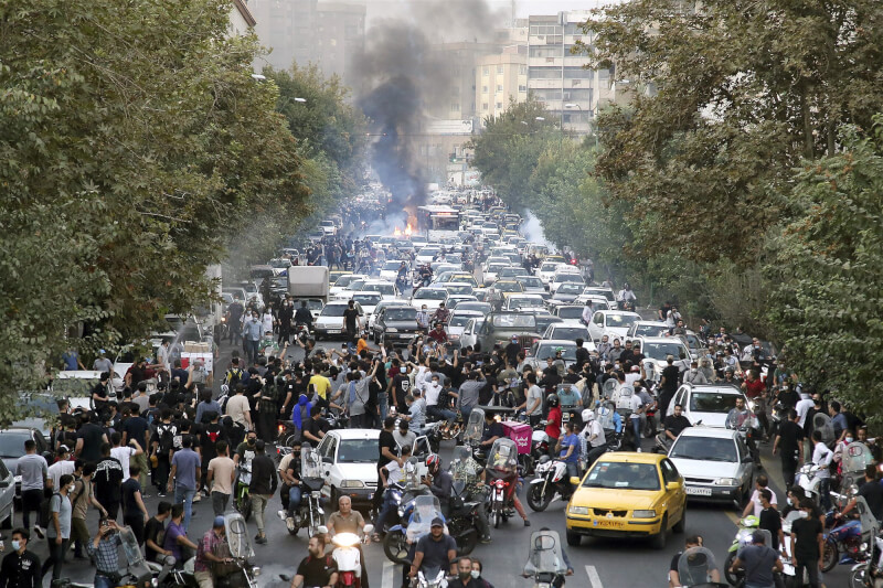 伊朗女子艾米尼9月在警察拘押期間身亡，引發全國示威，伊朗政府殘暴鎮壓，導致數百人死亡。圖為9月21日民眾在伊朗首都德黑蘭街頭抗議。（美聯社）