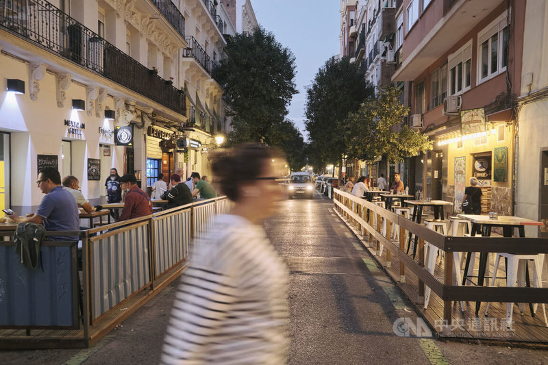 馬德里市中心錢貝里（Chamberí）區的國際啤酒街上，兩旁酒吧都將門前路邊停車格開闢為COVID露天座，整條街宛如一處有車行經的德國啤酒花園。中央社記者胡家綺馬德里攝  111年10月19日