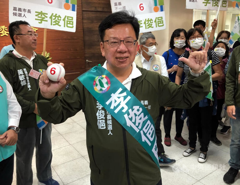 民進黨嘉義市長參選人李俊俋（前中）21日在選舉號次抽籤抽中6號，右手拿印有號次6號的棒球，象徵將做為嘉義市民的最佳捕手，接住人民的速球，期盼用未來4年時間讓嘉義市變得不一樣。中央社記者黃國芳攝  111年10月21日