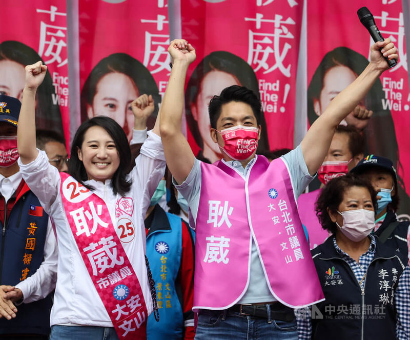 國民黨台北市長參選人蔣萬安（前右）23日出席同黨台北市議員參選人耿葳（前左）競選總部成立大會，兩人手拉手在台上一同造勢拚選票。中央社記者鄭清元攝  111年10月23日