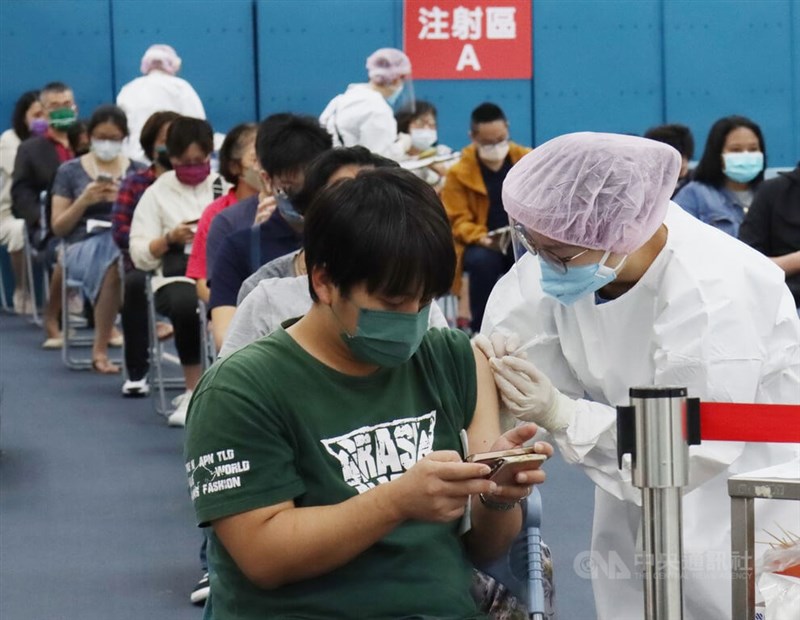 國內23日新增3萬5322例COVID-19本土病例。圖為民眾21日在台北市松山區一處接種站施打疫苗。（中央社檔案照片）