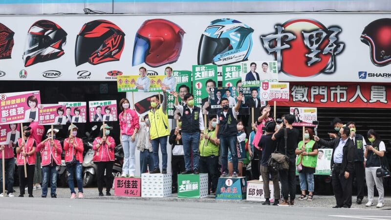 民進黨新北市長參選人林佳龍（前台中）24日上午站在台北橋新北端路口拜票，向民眾揮手致意，爭取支持。中央社記者趙世勳攝 111年10月24日