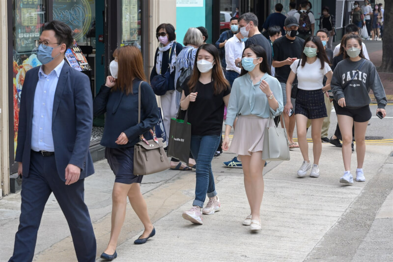 圖為香港市民戴著口罩在灣仔街頭行走。（中新社）