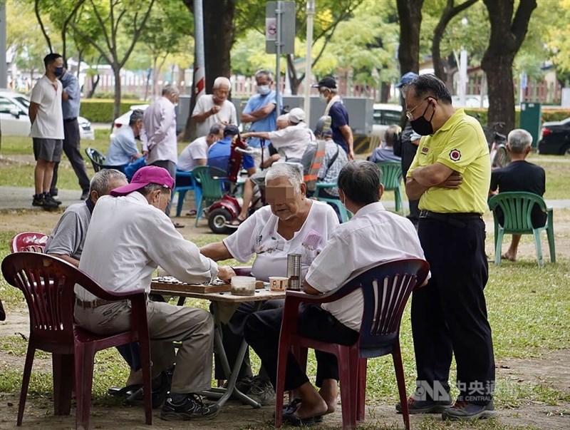 圖為25日午後高雄鳳山一處公園內不少長者齊聚下棋，多數人維持全程配戴口罩。（中央社檔案照片）