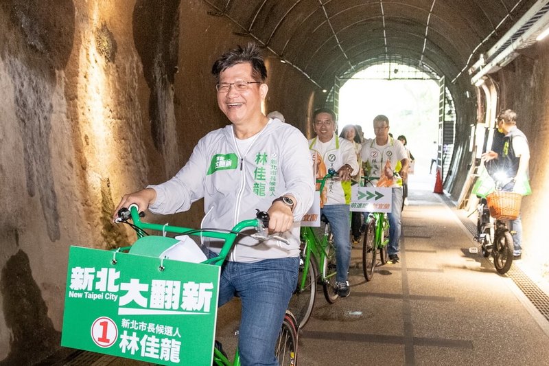 民進黨新北市長參選人林佳龍(前)與民進黨宜蘭縣長參選人江聰淵26日在新北市貢寮區福隆舊草嶺隧道騎腳踏車造勢,盼未來打造海岸線自行車道,推動觀光。(林佳龍競選辦公室提供)中央社記者黃旭昇新北傳真 111年10月26日
