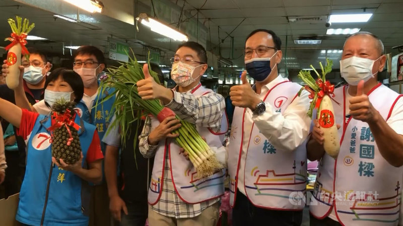 國民黨主席朱立倫（右2）26日上午陪同國民黨基隆市長參選人謝國樑（右3）前往基隆市成功市場拜票，有攤商熱情送上菜頭和蒜苗，預祝謝國樑高票當選。中央社記者王朝鈺攝  111年10月26日