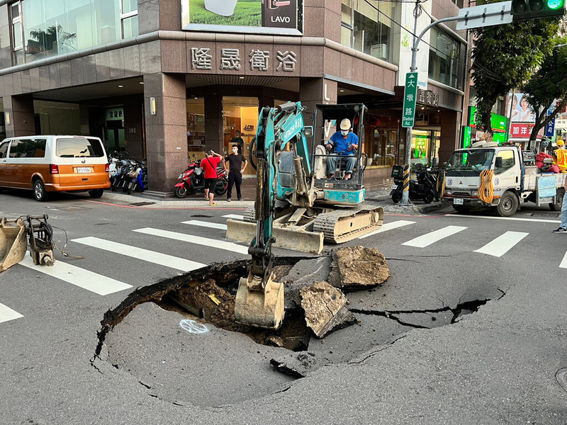 台中市南屯區大墩路與大墩五街口27日突然發生路面塌陷，柏油路上出現一個大坑洞，台中市政府檢測後初判為路底嚴重冒水，經檢測為自來水管漏，並已通報自來水公司處理，自來水公司廠商也派員到場搶修。（台中市政府提供）中央社記者郝雪卿傳真  111年10月27日