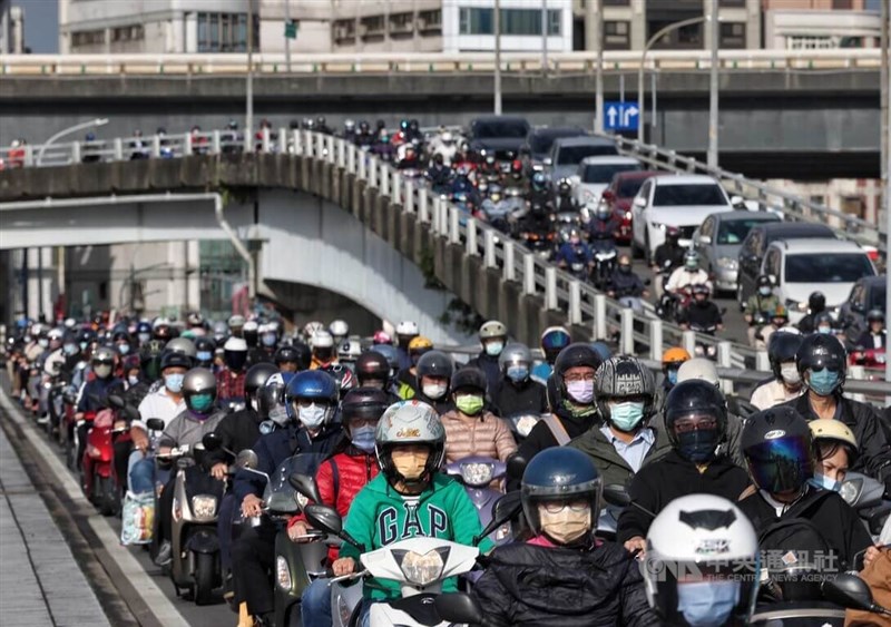 圖為24日上午台北橋，不少機車騎士戴好口罩通勤。（中央社檔案照片）