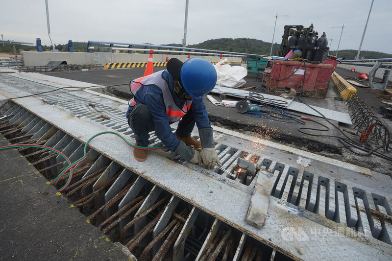 105年6月，金門大橋第2包商因進度嚴重落後遭解約；歷經3次招標，東丕於當年11月得標。東丕董事長王銀和接受中央社訪問表示，全盛時期東丕有500人投入大橋，隨階段性任務完成，後期剩下約200員工。圖為工人進行收尾的伸縮縫工程。中央社記者徐肇昌攝 111年10月29日