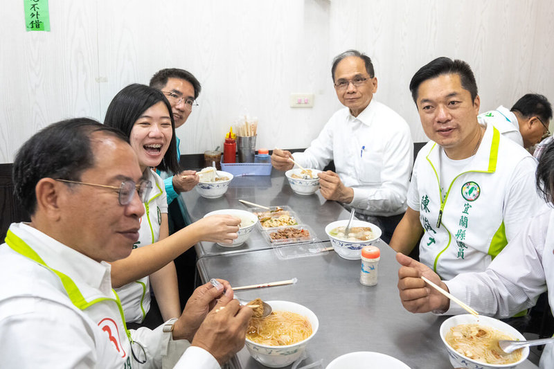 立法院長游錫堃（後右）29日在民進黨宜蘭縣長參選人江聰淵（後左）等人陪同下走訪宜蘭，開心品嚐美食小吃。（讀者提供）中央社記者王朝鈺傳真111年10月29日