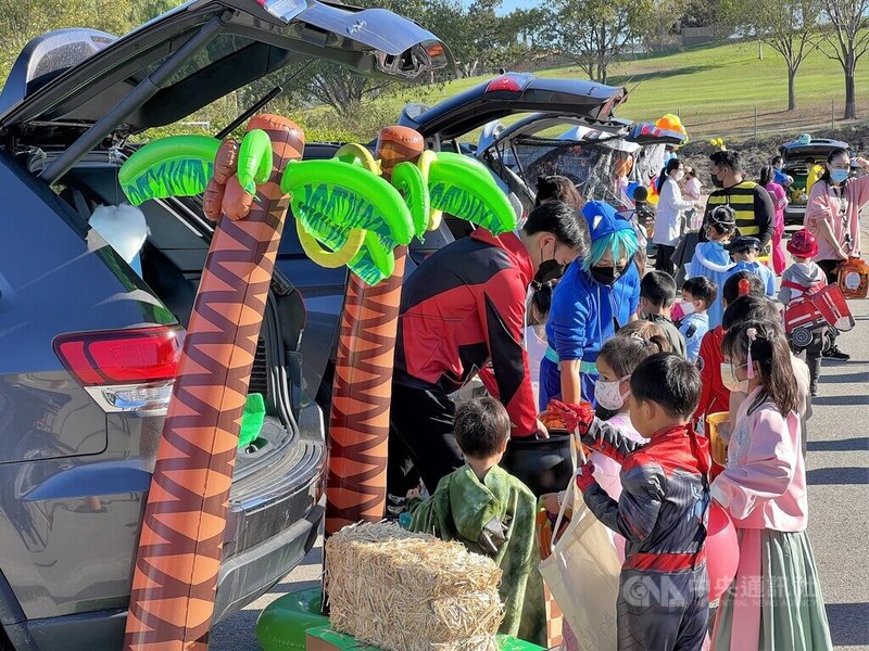 美國加州的慈濟小學28日舉行萬聖節活動，家長在後車廂布置應景裝飾，身穿特殊服裝的學童一輛接著一輛要糖。中央社記者林宏翰洛杉磯攝  111年10月30日