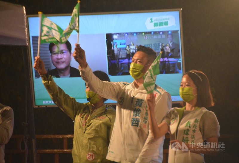 民進黨新北市長參選人林佳龍競選辦公室30日晚間在板橋區舉辦音樂晚會造勢，市議員戴瑋姍（右起）、黃俊哲等站台懇託，確診COVID-19的林佳龍以視訊方式參加。中央社記者黃旭昇新北攝  111年10月30日