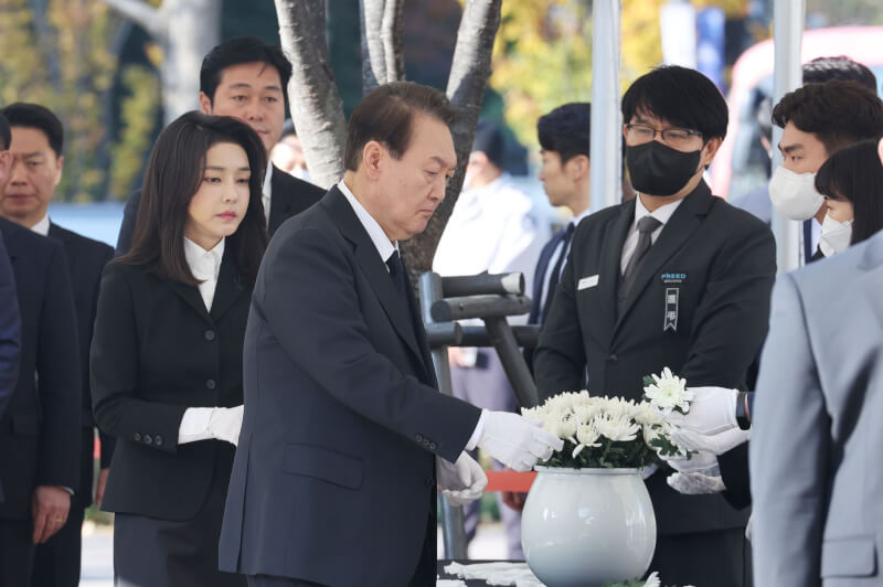 韓國首爾梨泰院萬聖節推擠踩踏事件造成154人喪命，總統尹錫悅（中）31日偕同夫人（前左）在祭壇獻上白花哀悼。（韓聯社）