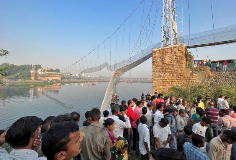印度西部古茶拉底省莫比鎮30日發生吊橋斷落事件，民眾31日聚集在斷橋旁。（路透社）
