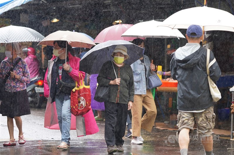 氣象局1日表示，受東北季風及颱風奈格影響，北部、東半部防大雨。圖為台北市北投區民眾撐傘外出。（中央社檔案照片）