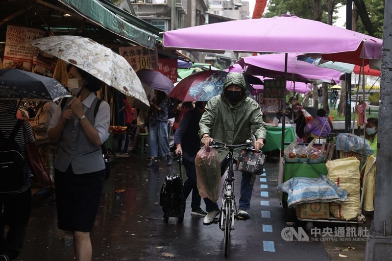 圖為台北市中山區民眾穿雨衣在市場採買。（中央社檔案照片）