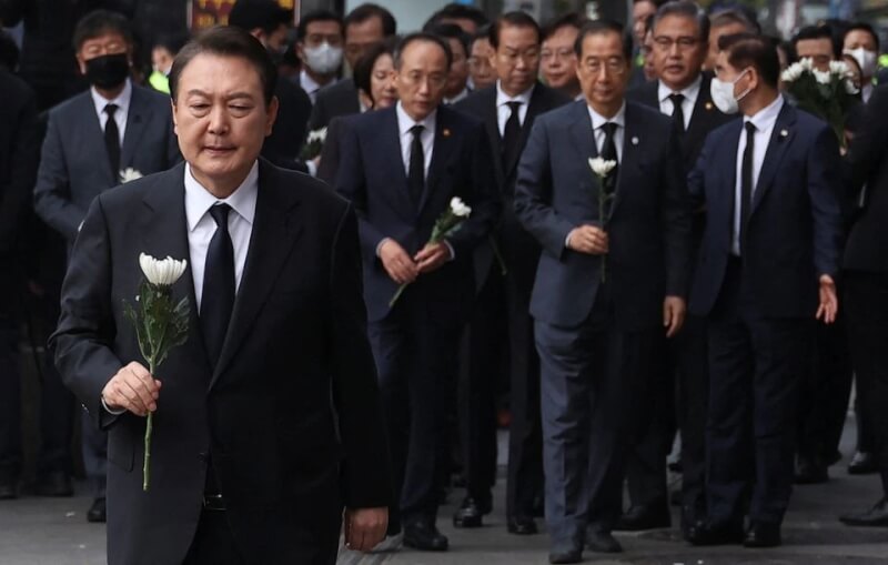圖為1日韓國總統尹錫悅（前）向受難者致意。（路透社）