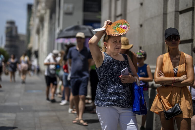 世衛7日表示，歐洲今年以來至少有1萬5000人死於高溫炎熱天氣，其中西班牙和德國受影響最重。圖為7月18日馬德里街頭民眾在高溫下試圖遮蔽豔陽。（美聯社）