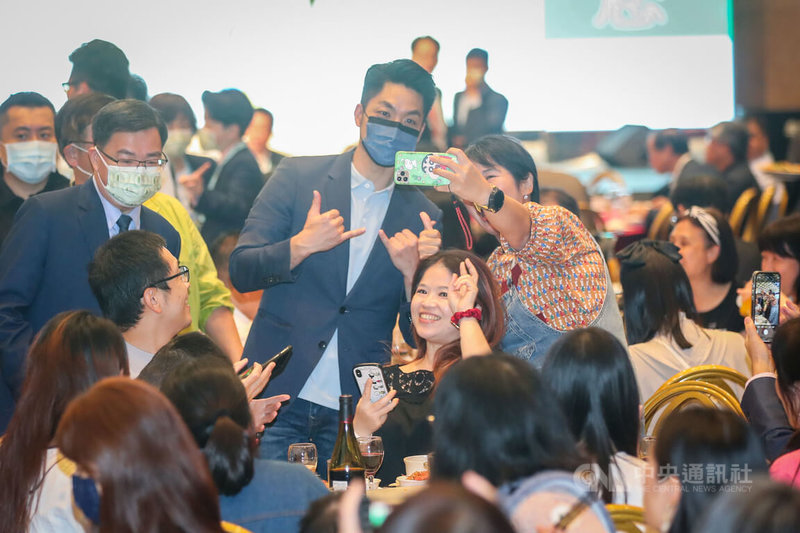 國民黨台北市長候選人蔣萬安(立者後中左)11日晚間出席台北市醫檢師公會「111年度防疫陣線感恩有您」會員聯誼餐敘,逐桌致意,有民眾開心和蔣萬安自拍留念。中央社記者裴禛攝 111年11月11日