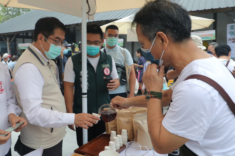 台南市長黃偉哲（左）13日出席在東山區農會廣場舉辦的2022東山咖啡節開幕活動，試喝現場展售的咖啡產品。（台南市政府提供）中央社記者楊思瑞台南傳真 111年11月13日
