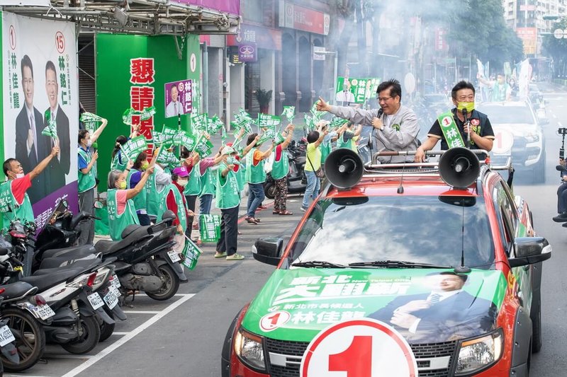 民進黨新北市長候選人林佳龍（車上左）13日率市議員參選人在新北市土城區車隊掃街，透過麥克風向市民請託拜票。（林佳龍競選辦公室提供）中央社記者黃旭昇新北傳真  111年11月13日