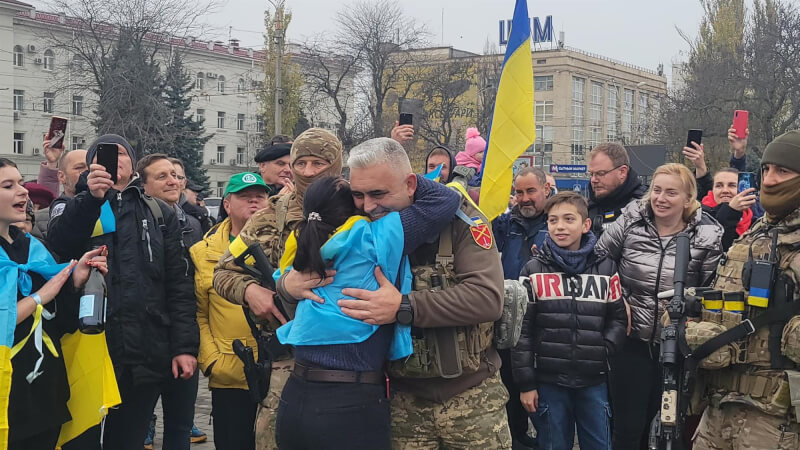 烏克蘭軍人11日抵達赫松市中心，居民披著國旗歡騰迎接，並擁抱軍人。（圖取自facebook.com/okPivden）