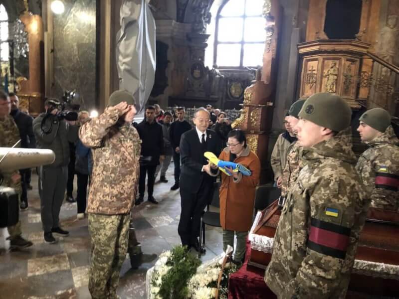 曾聖光戰死烏克蘭，烏國軍方14日舉辦追思儀式，軍方代表向曾聖光致敬，駐波蘭代表陳龍錦（黑色西裝者）全程陪同家屬。（外交部提供）中央社記者黃雅詩傳真 111年11月14日