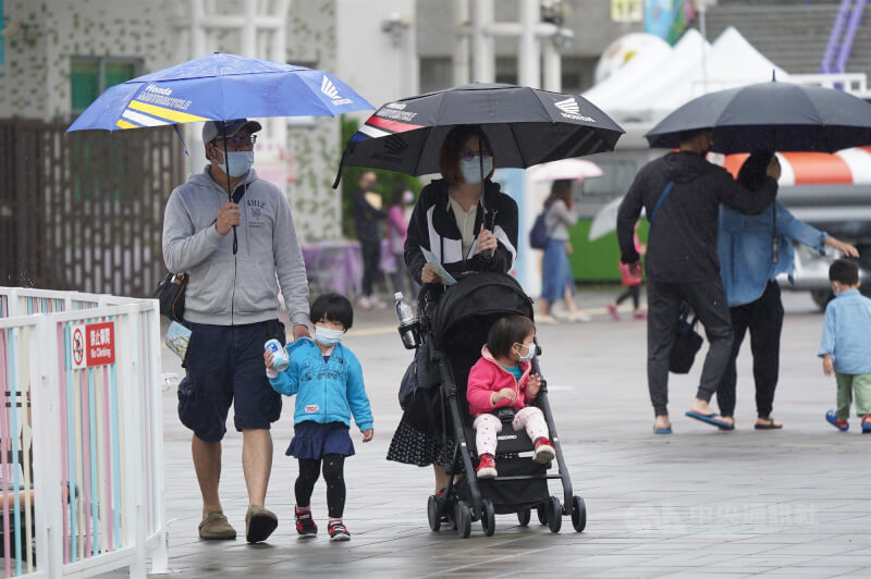 氣象專家吳德榮表示，14至16日大台北、東半部有局部雨。圖為家長撐傘帶孩童至台北市兒童新樂園遊玩。（中央社檔案照片）