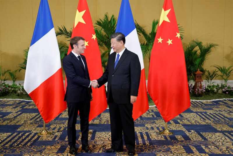 法國總統馬克宏（左）與中國國家主席習近平（右）15日在G20峰會場邊見面握手。（法新社）