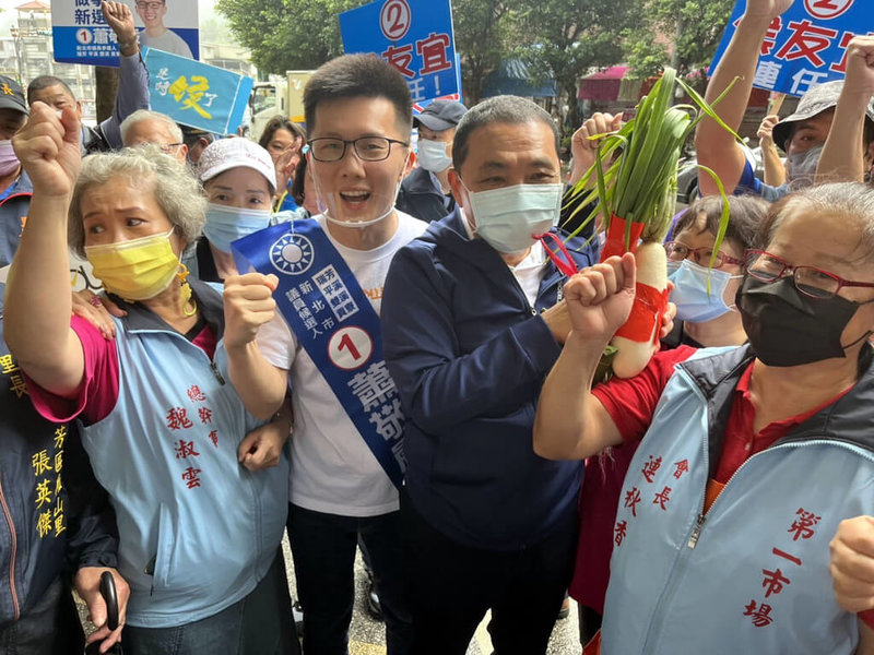 國民黨新北市長候選人侯友宜（前左3）力拚連任，16日到瑞芳區第一市場掃街拜票，受到許多鄉親熱烈歡迎，爭相致贈菜頭、蒜等表達祝福，也高喊「凍蒜」口號。（侯友宜競選辦公室提供）中央社記者黃旭昇新北市傳真 111年11月16日