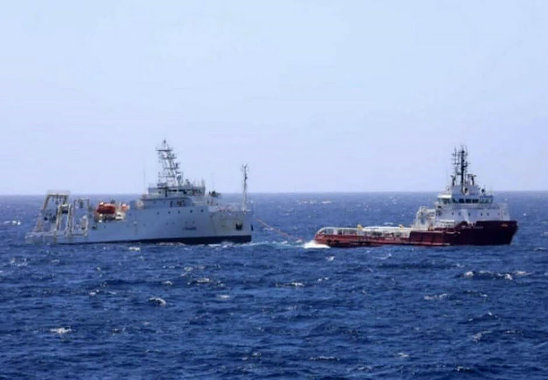 海巡署日前獲報，研究船「新海研1號」（左）在菲律賓西北部外海失去動力，隨即通報艦艇協助戒護，台大委託的拖船（右）也已到場完成拖帶，預計18日下午將返抵高雄港。（海巡署提供）中央社記者曾以寧傳真  111年11月17日