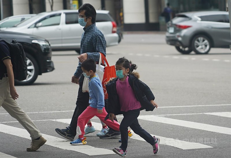 圖為家長帶孩子在台北市松山區活動，已穿上長袖衣物、外套，避免感冒受涼。（中央社檔案照片）