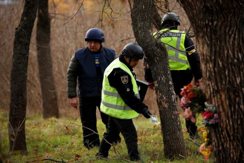 烏克蘭警方與法醫16日在赫松尋找俄軍攻擊烏克蘭人的證據。（路透社）